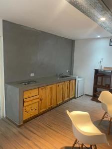 耶尔瓦布埃纳LO DE TIN的厨房配有水槽、木制橱柜和椅子