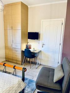 伊古迈尼察S&A Modern Apartment的一间卧室配有一张床、一张桌子和一把椅子
