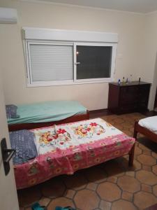 瓜鲁雅Mansão Mar casado的一间卧室设有两张床和窗户。