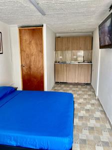 麦德林Hermoso apartamento en San Pablo Guayabal的一间卧室设有蓝色的床和木门