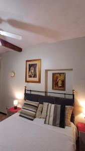 威尼斯La Dolce Venezia Guesthouse的卧室配有一张床,墙上挂有两张照片