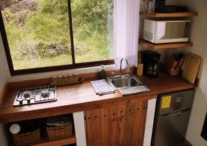 基多Cabaña en la montaña Ilalo - Quito的厨房配有带水槽的柜台和窗户。