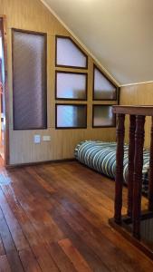 瓦尔迪维亚Cygnus Hostel的带窗户的客房内设有两张床的房间