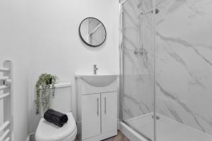 Rock FerryBirkenhead Aparthotel的带淋浴、卫生间和时钟的浴室