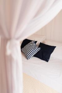 托兰克索Villa Joá - Casa的一张带黑色枕头的白色床