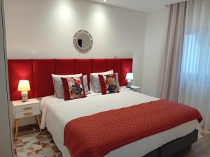 凡道Garden House Fundão - Suíte 203的一间卧室配有一张大床和红色床头板