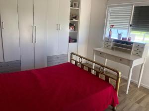 佩洛塔斯Casa das Maria Praia do Laranjal的一间卧室配有一张带红色毯子的床