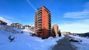 帕苏德尔托纳莱Diamante ampio monolocale stile chalet alpino的一条雪覆盖的街道中间的高楼