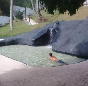 瓜拉派瑞Pousada Vila Sol Maior的游泳者在水上乐园的游泳池游泳