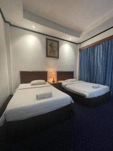 KartosuroSadinah Sahid By Meliala的酒店客房设有两张床和窗户。