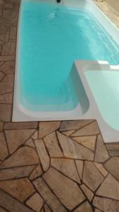 里贝朗普雷托Espaço lazer的一座拥有石头地板和蓝色海水的游泳池