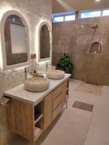 库塔Puspa Ayu Villas & Apartments的浴室设有2个水槽和2面镜子
