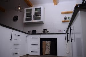 OtseKanana Villas的厨房配有白色橱柜和炉灶烤箱。