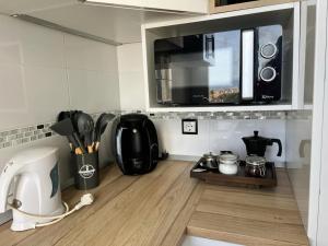 马拉加Espectacular apartamento junto al mar, con piscina en Málaga的厨房配有咖啡机和微波炉