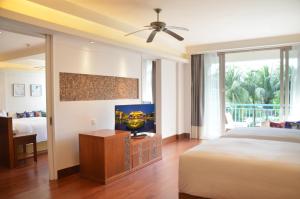 三亚三亚亚龙湾华宇度假酒店的一间卧室配有一张床和一台平面电视