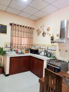 TalagalaHappy Nest的厨房配有木制橱柜和炉灶烤箱。