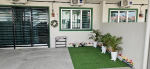 安顺Teluk Intan Homestay Landed 3BR2B的一间设有绿色地毯和2个窗户的客房