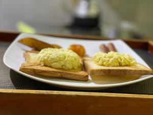 达瓦拉维The Mastodon Valley Safari Resort的桌上的烤面包片上放鸡蛋的白盘