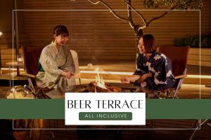 天童市Ichiraku tendo spa & brewery的两个女人坐在桌子旁,火上烧