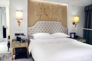 广州广州伊士丹顿酒店的卧室配有一张大白色的床和大床头板