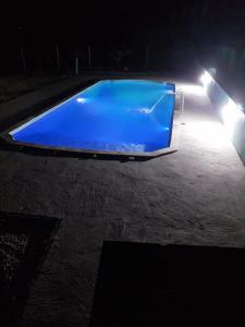 若阿诺波利斯Casa de campo Maciel的夜晚带灯光的蓝色游泳池