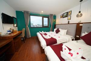 河内NT Elysian hotel的酒店客房配有两张床和一张书桌