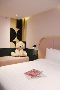Pom PrapThe Quarter Ratchathewi by UHG的床上坐着泰迪熊