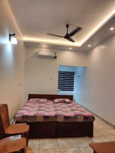 马拉普兰Thekkumpuram Tourist Home的一间卧室配有一张床和吊扇