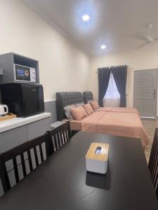 哥打巴鲁D'Laman Cottage Kota Bharu kelantan的一间卧室配有一张床、一台电视和一张桌子