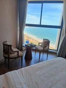 Ấp Thiẹn ÁiLuxury APEC MANDALA MŨI NÉ SG HAPPY HOUSE的酒店客房设有一张床,享有海景。