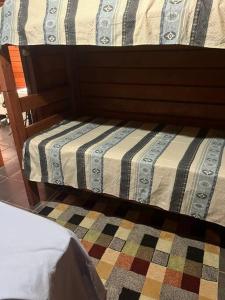 伊图Chalé aconchegante的一张带条纹棉被的床