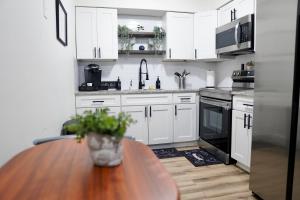 坦帕Jay's Cozy Escape的厨房配有白色橱柜和木桌