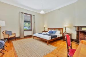 塔南达巴罗莎葡萄园宾馆的一间卧室配有一张床、一把椅子和一个壁炉