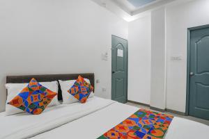 那格浦尔FabExpress Pramila Prakash的一间卧室配有带色彩缤纷枕头的床。