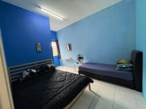 丹那拉打Nurul Aisyah Homestay的一间卧室设有两张床和蓝色的墙壁