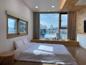 木浦市38th Street Guesthouse的卧室设有白色的床和大窗户