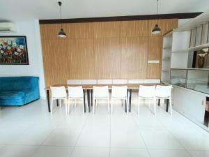 PuunggolakaUrbanview Hotel B Liv Kendari的一间带桌子和白色椅子的用餐室
