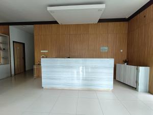 PuunggolakaUrbanview Hotel B Liv Kendari的木墙客房内的白色大柜台