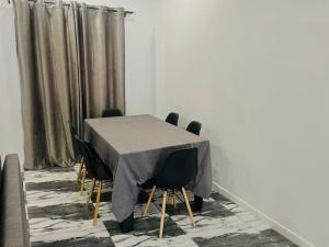 KpaliméLes 9 Plurielles T 2 KPALIME KOUMA KONDA的一张桌子、黑色椅子和灰色的桌布