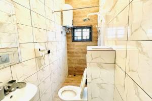 KpaliméLes 9 Plurielles T 2 KPALIME KOUMA KONDA的浴室配有白色卫生间和盥洗盆。