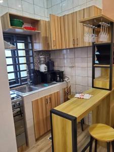 KpaliméLes 9 Plurielles : Studio 1 KPALIME KOUMA KONDA的厨房配有木制橱柜、桌子和水槽。