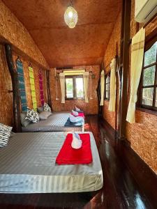 桑卡武里พาราไดซ์รีสอร์ต สังขละบุรี Paradise Resort at Sangkhlaburi的一间设有两张床和红色毯子的房间