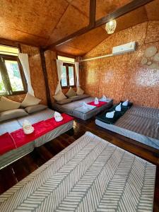 桑卡武里พาราไดซ์รีสอร์ต สังขละบุรี Paradise Resort at Sangkhlaburi的带两张床和两个窗户的房间