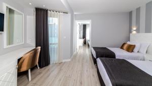 马尔马里斯Motto Premium Hotel&Spa的酒店客房配有两张床和一张书桌