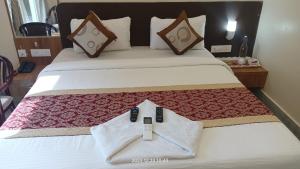 布巴内什瓦尔HOTEL SJ PRIDE INN的酒店客房,配有带两个遥控器的床