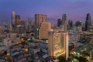 曼谷Hilton Garden Inn Bangkok Silom的城市天际线,夜晚有灯光的建筑