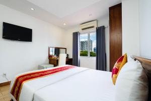 胡志明市King Hotel Saigon Airport的卧室配有白色的床和电视。