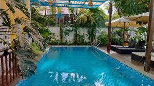 会安Hoi An Heart hostel Villa的庭院内的大型游泳池,设有庭院