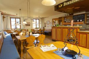 魏勒-锡默贝格帕斯特酒店的餐厅设有木桌、椅子和柜台