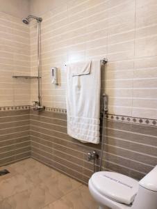 伊斯兰堡Riviera Courtyard Guest House Islamabad的浴室设有卫生间和带毛巾的淋浴。